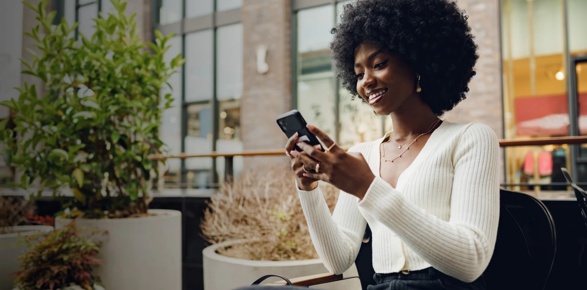 A KwiGO customer discovering deals on her phone in Kigali